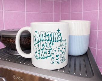 Protecting My Peace Cat Mug (325 ml) – Cute ceramic mug for cat lovers, friends & colleagues | Self-care gift