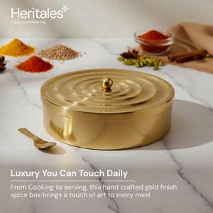 May include: A gold-colored spice box with a matching spoon, featuring a circular design on the lid. The image includes various spices in small bowls and piles. Text on the image reads "Luxury You Can Touch Daily".