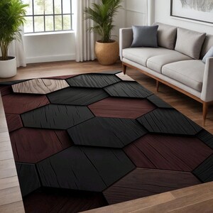 May include: A rectangular area rug with a geometric pattern. The rug features a repeating design of dark brown, black, and light brown wooden planks arranged in a hexagonal pattern. The rug is placed on a hardwood floor.