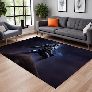 Könnte beinhalten: Ein großer rechteckiger Teppich mit einer dunklen, dramatischen Szene. Eine schwarz-weiße Figur mit rotem Mund und weißem spinnenartigen Design wird vor einem dunkelblauen, bewölkten Hintergrund dargestellt. Der Teppich liegt auf einem hellen Holzboden.