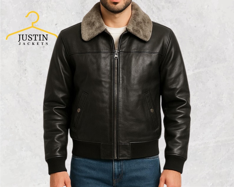 Puede incluir: Chaqueta de cuero negro con cuello de borrego, cremallera y dos bolsillos delanteros. La chaqueta tiene dobladillo y pu&ntilde;os acanalados. La marca "JUSTIN JACKETS" es visible en la esquina superior izquierda.