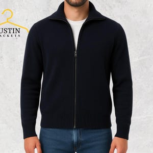 May include: A navy blue zip-up jacket with a ribbed collar and cuffs. The jacket has a full-length zipper and is worn over a white t-shirt. The logo "JUSTIN JACKETS" is visible in the upper left corner.