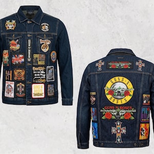 Puede incluir: Chaqueta vaquera azul oscuro con múltiples parches con logotipos y gráficos de bandas de rock. Se ven la parte delantera y trasera de la chaqueta, mostrando una variedad de diseños, incluido el logotipo de Guns N' Roses. La chaqueta tiene cierre de botones y dos bolsillos en el pecho.
