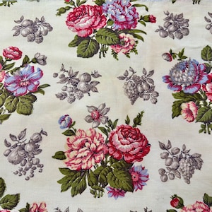 May include: Cream-colored fabric with a repeating floral pattern. Large, detailed bouquets of red, pink, and blue flowers with green leaves are interspersed with gray fruit illustrations. The fabric has a vintage, botanical aesthetic.