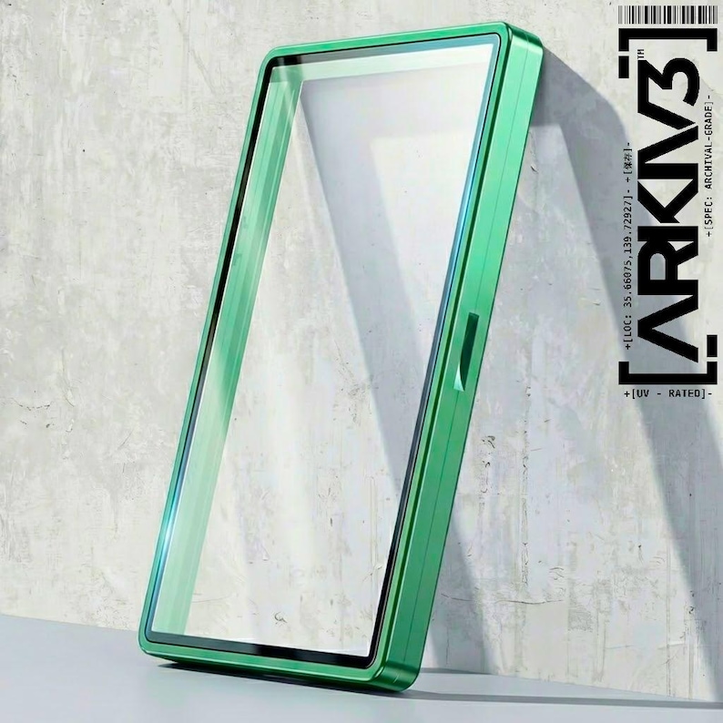 May include: A rectangular, green-framed object with a clear, transparent center, leaning against a textured, light gray wall. The frame has a metallic sheen. The text "ARKIV3" and other technical details are printed on the right side.