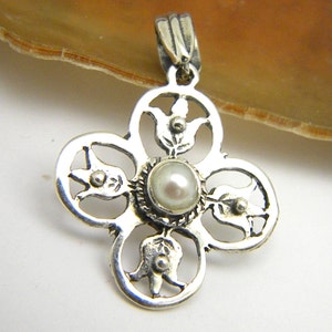 May include: Silver pendant featuring a delicate floral design with a white pearl at its centre.