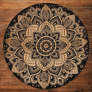 May include: A round, black and tan mandala design. The intricate pattern features a central floral motif surrounded by detailed, symmetrical elements. The design is set against a black background with a tan-colored floral pattern.