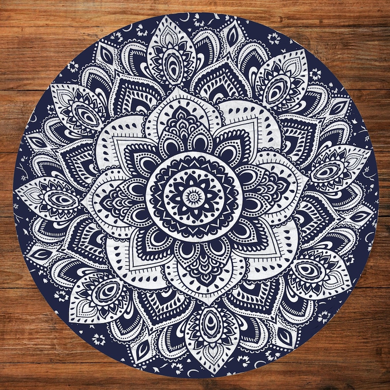 Puede incluir: Un dise&ntilde;o de mandala redondo, azul marino y blanco. El intrincado patr&oacute;n presenta un motivo floral central rodeado de elementos sim&eacute;tricos detallados. El dise&ntilde;o se establece sobre un fondo azul oscuro, creando un contraste llamativo.