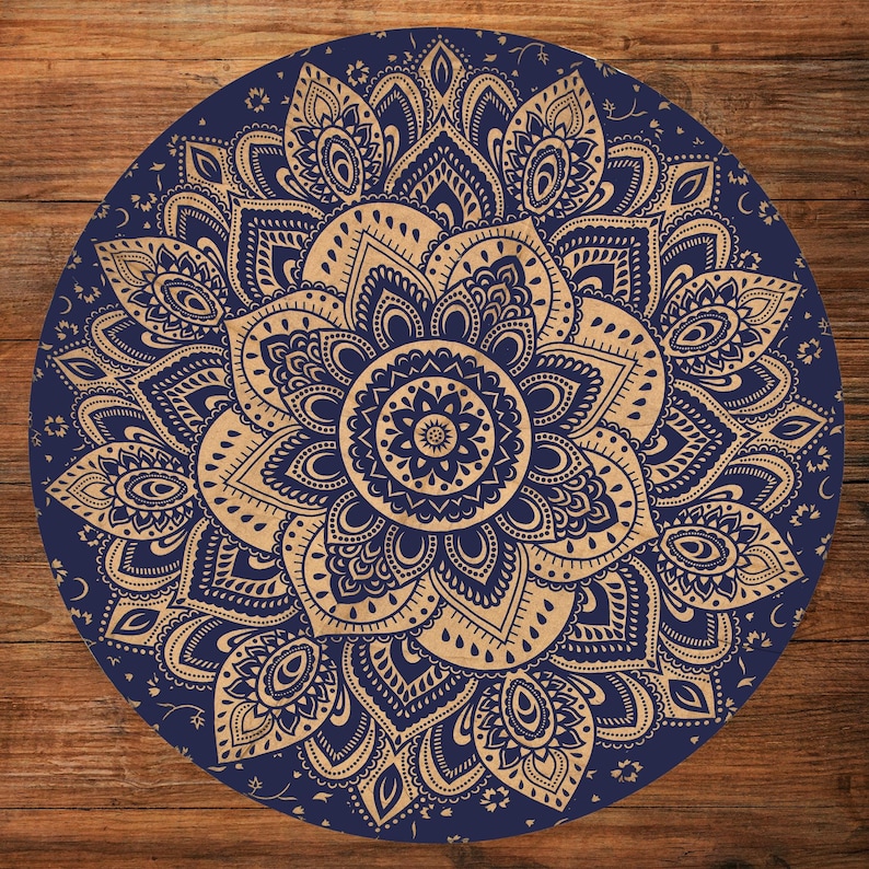 Puede incluir: Dise&ntilde;o de mandala circular azul marino y beige. El intrincado patr&oacute;n presenta elementos florales y geom&eacute;tricos. El mandala est&aacute; centrado y sim&eacute;trico, con l&iacute;neas y formas detalladas. El fondo es una superficie de madera.