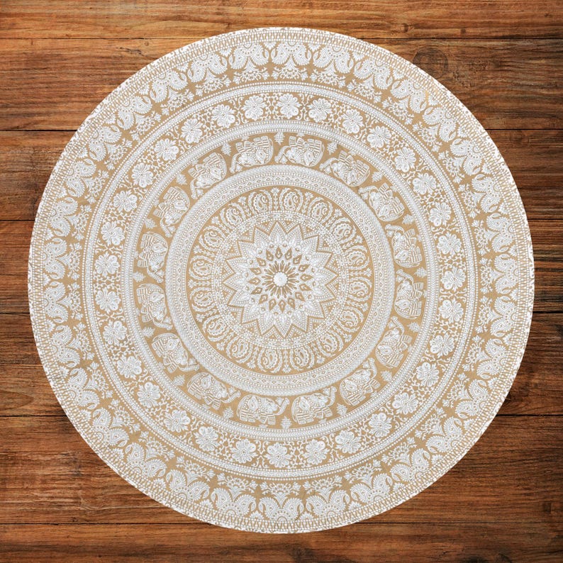Puede incluir: Tapiz mandala redondo beige y blanco con intrincados patrones florales y de elefantes. El tapiz presenta un dise&ntilde;o central de estrella y m&uacute;ltiples c&iacute;rculos conc&eacute;ntricos de obras de arte detalladas. El tapiz est&aacute; hecho de un material suave.
