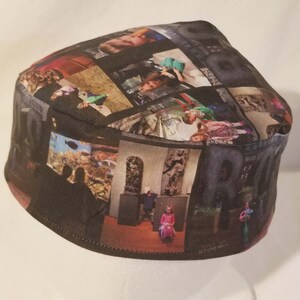 Op de afbeelding: Een zwarte stoffen kippa met een collage van foto's erop gedrukt. De foto's zijn van verschillende mensen en plaatsen, waaronder een gezin, een museum en een strand.