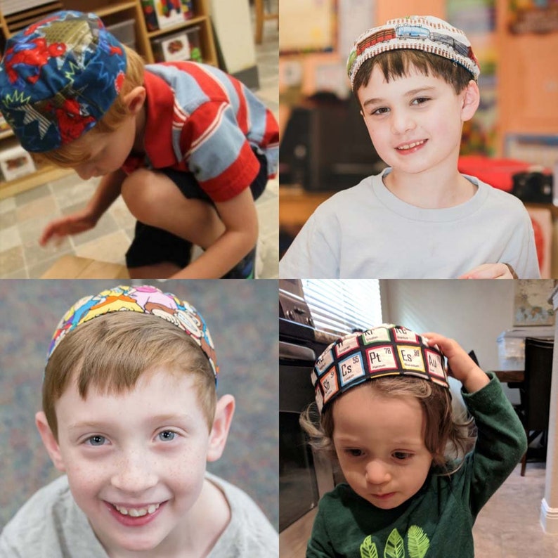 Op de afbeelding: Drie kinderen dragen verschillende gepatroneerde kippahs. De kippahs zijn kleurrijk en hebben verschillende ontwerpen, waaronder een stripboek-stijl, een periodiek systeem en een transportthema.