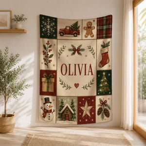 May include: A rectangular woven throw blanket featuring a cream-colored center panel with the name OLIVIA in red letters, surrounded by a grid of festive holiday illustrations including a red truck, gingerbread man, and snowman.