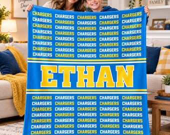 May include: A blue fleece blanket featuring a repeating pattern of the word CHARGERS in yellow text, with the name ETHAN printed in large yellow block letters across the center, separated by white horizontal stripes.