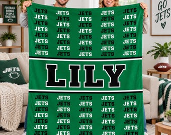 May include: A green fleece blanket featuring a repeating pattern of the word JETS in black text. A wide horizontal band across the center displays the name LILY in large black capital letters with a white outline on a green background.