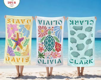 May include: Three beach towels with personalized names. One is yellow with a starfish and floral design, the second is white with a turtle and floral design, and the third is light blue with seashell designs. Each towel has a name printed on it.