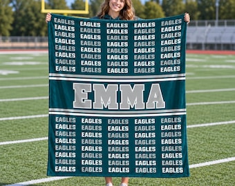 May include: A teal fleece blanket featuring a repeating pattern of the word EAGLES in white and grey text, with a central horizontal band displaying the name EMMA in large, bold, grey-outlined white block letters against a teal background.