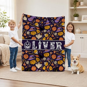May include: A rectangular fleece blanket featuring a dark purple background with a repeating Halloween pattern of orange jack-o'-lanterns, purple witch hats, ghosts, and lollipops. The center displays the name OLIVER in large white letters.
