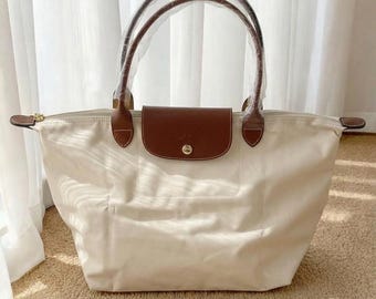 Bolso tote grande de nailon blanco con detalles de cuero, plegable y ligero para uso diario.