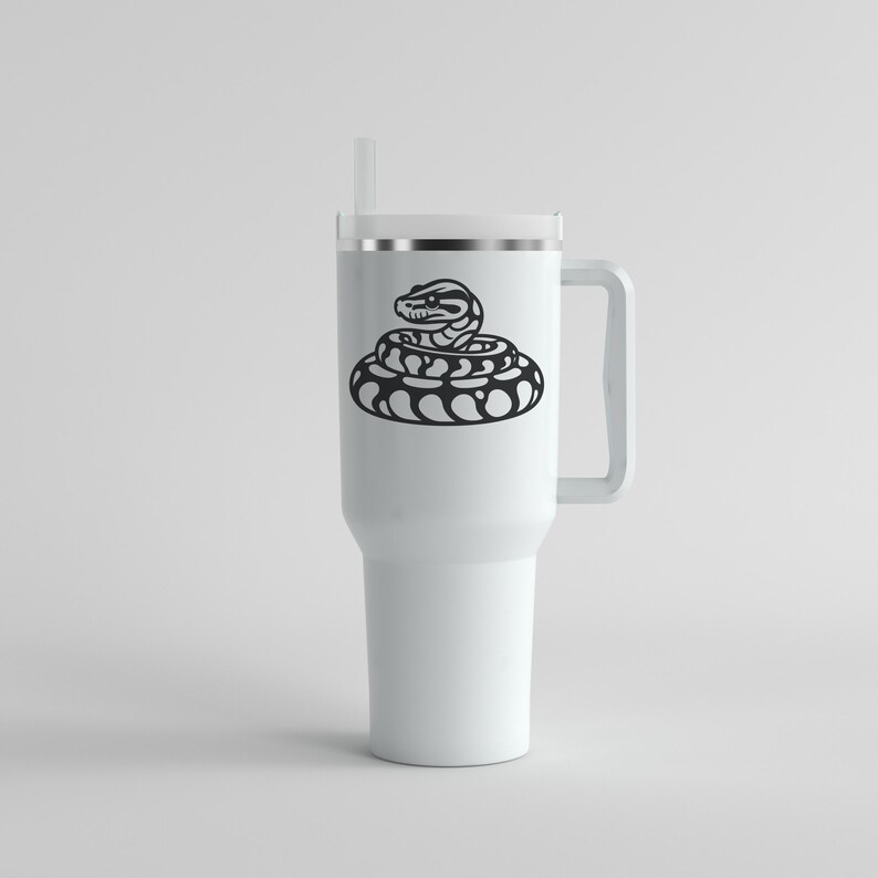 May include: A white travel mug featuring a black illustration of a coiled snake. The mug has a handle, a lid, and a straw. The snake design is a bold, minimalist graphic, suitable for those interested in reptiles.