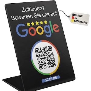 Könnte beinhalten: Schwarzes Acrylschild mit Google-Logo und QR-Code. Der Text "Zufrieden? Bewerten Sie uns auf Google" und "SCAN ME" ist zu sehen. Ein angehängtes Etikett zeigt "MADE IN GERMANY".