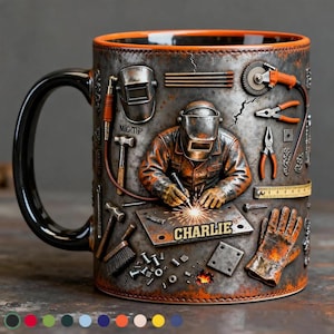 May include: A ceramic mug with a black handle and an orange rim. The mug features a detailed relief design of a welder at work, surrounded by tools. The name "CHARLIE" is on a metal plate. The mug has a rustic, industrial aesthetic.