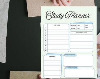 May include: A light green study planner with the title "Study Planner" in elegant script. The planner includes sections for a time table, today's subjects, deadlines, study progress, and important notes. The planner is on a dark surface.