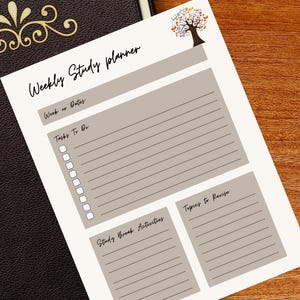 Könnte beinhalten: Ein wöchentlicher Studienplaner mit einer Baumillustration und dem Text "Weekly Study Planner". Der Planer enthält Abschnitte für Daten, Aufgaben, Studienpausenaktivitäten und zu wiederholende Themen. Ein braunes, ledergebundenes Notizbuch ist im Hintergrund zu sehen.