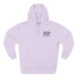 May include: A light purple hoodie with a front pocket and a drawstring hood. The text "FIFA W.C. 2026 UNITED 26" is printed on the upper chest. The hoodie is made of a soft material.