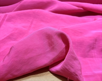 Puede incluir: Tela rosa brillante con una textura suave y fluida. La tela está drapeada, mostrando pliegues y sutiles variaciones de color. El material parece ligero, posiblemente seda o un tejido delicado similar.