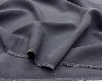 May include: Close-up of a dark gray fabric with a soft, flowing texture. The fabric has a subtle sheen and a raw, fringed edge. The folds and drapes of the material create shadows and highlights, showcasing its fluidity. Ideal for apparel and home decor.