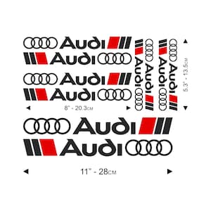 Può includere: Un set di adesivi con il logo Audi, caratterizzato dall'emblema a quattro anelli e dal testo in nero, rosso e bianco. Il foglio include varie dimensioni con misure indicate come 8 pollici per 20,3 cm, 11 pollici per 28 cm e 5,3 pollici per 13,5 cm.