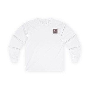 Könnte beinhalten: Weißes Langarmshirt mit einem kleinen quadratischen Design auf der oberen linken Brust. Das Design ist in einem gedämpften Braunton gehalten und zeigt ein minimalistisches Blumen- oder abstraktes Muster. Das Shirt hat einen Rundhalsausschnitt und lange Ärmel.
