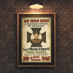 以下が含まれることがあります： 「AN IRISH HERO!」と「1 IRISHMAN DEFEATS 10 GERMANS.」のテキストが入った額入りのヴィンテージポスター。マイケル・オレアリー軍曹の肖像と「IRISH GUARDS」の文字が特徴です。レンガの壁に飾られています。