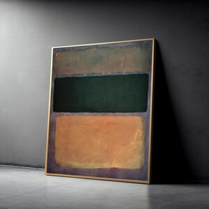 Könnte beinhalten: Abstraktes Gemälde mit goldenem Rahmen. Das Kunstwerk zeigt drei horizontale Farbblöcke: ein gedämpftes Grün oben, ein dunkles Grün in der Mitte und ein Orange-Braun unten. Das Gemälde lehnt an einer dunkelgrauen Wand.