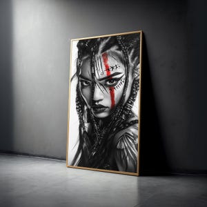 Puede incluir: Retrato en blanco y negro enmarcado de una persona con intrincados cabellos trenzados y marcas faciales. Una audaz franja roja acentúa la cara. La obra de arte se exhibe contra una pared gris, con un marco dorado.