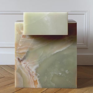 May include: A square onyx side table with a rectangular top. The table features a mix of green, brown, and cream colors with natural veining. The top is a lighter shade of green. The table is a decorative accent piece.