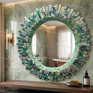 May include: A round decorative mirror with a green and gold sunburst design. The mirror's frame is adorned with rectangular, multi-colored stones in shades of green and blue. The mirror is mounted on a green marble wall.