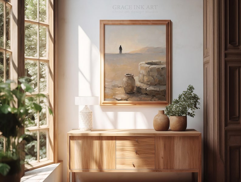 a serene indoor setting with a wooden cabinet, a painting of a desert landscape, and a lamp on a table.