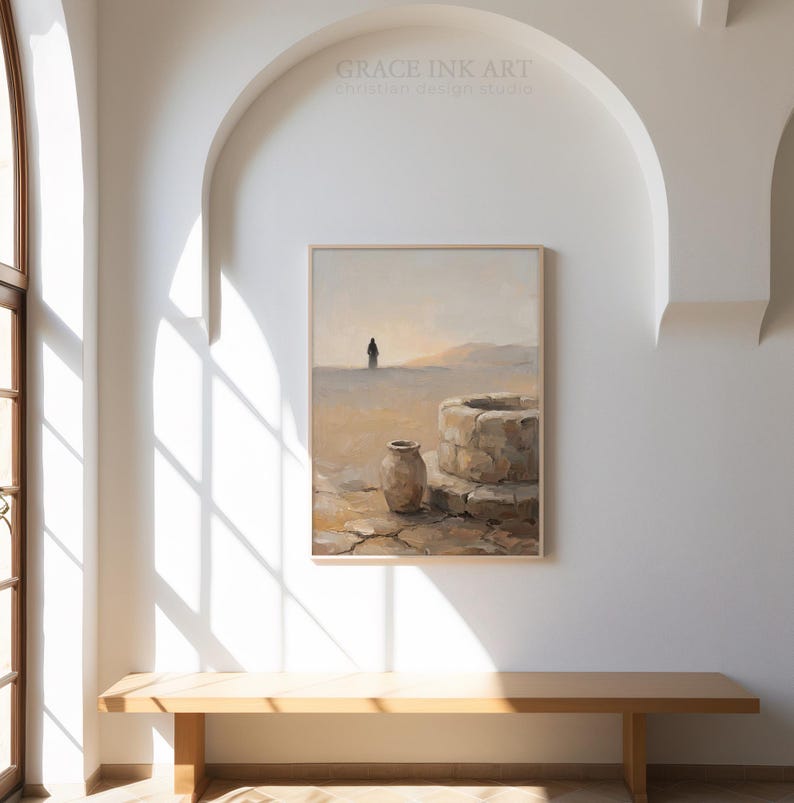 a large painting of a desert landscape hanging on a white wall, with a wooden bench in front of it.