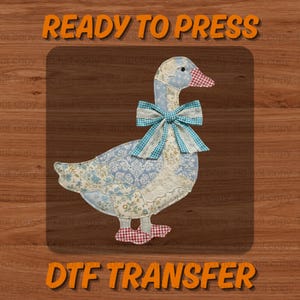 May include: A fabric goose design with a blue and white floral pattern, a gingham bow, and red gingham feet. The words "READY TO PRESS" and "DTF TRANSFER" are in orange text.