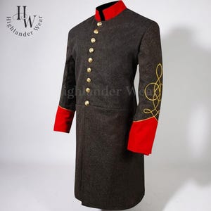 Könnte beinhalten: Ein dunkelgrauer Mantel im Militärstil mit rotem Kragen und Manschetten. Der Mantel hat goldene Knöpfe und goldene Stickereien am Ärmel. Das Logo "Highlander Wear" ist sichtbar.