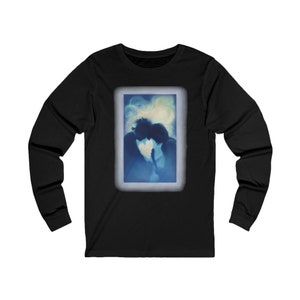 Op de afbeelding: Zwart longsleeve t-shirt met een afbeelding van twee silhouetten die elkaar omhelzen in een blauw en wit licht. De afbeelding is omlijst in een wit rechthoek.
