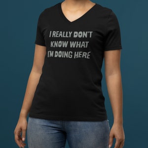 Puede incluir: Camiseta negra de cuello en V con el texto "I really don't know what I'm doing here" en color gris plateado.