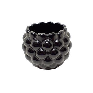 May include: A glossy black ceramic bowl featuring a textured exterior composed of numerous rounded, bubble-like protrusions. The vessel has a wide, open top with a scalloped rim edge, creating a spherical shape with a smooth, reflective finish.