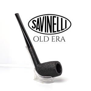 Op de afbeelding: Een zwarte tabakspijp met een getextureerde, rustieke afwerking en een lange, gladde steel. De tekst SAVINELLI en OLD ERA staat in het zwart boven de pijp gedrukt. De pijp rust op een doorzichtige, gebogen kunststof standaard tegen een witte achtergrond.