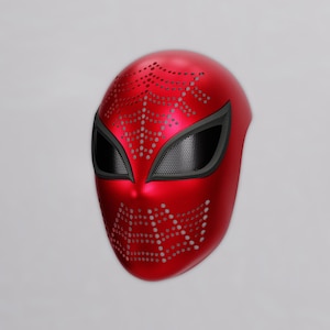 May include: A metallic red full-face mask featuring a perforated spiderweb pattern across the forehead and chin areas. The mask includes two large, almond-shaped eye openings framed in black with a fine black mesh screen covering the lenses.