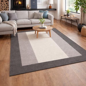 May include: A set of three ceramic mugs with a speckled, cream-colored glaze. Each mug features a different hand-painted design: a blue and green leaf, a yellow flower, and a red berry. The mugs have a simple, modern design.