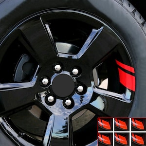 May include: Glossy black car wheel with silver lug nuts and a red stripe accent. The wheel is mounted on a black tire. The image also shows a set of red stripe accents.