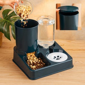May include: A teal pet feeder with a food dispenser, water bottle, and a bowl with a paw print. The food dispenser is being filled with pet food. The water bottle is clear and cylindrical. The feeder is on a wooden surface.